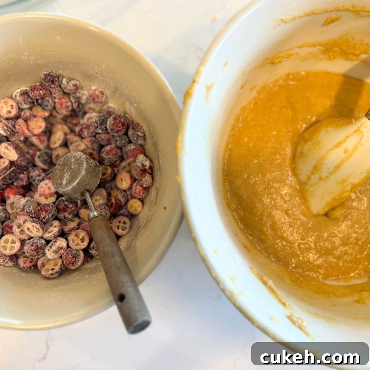 making cranberry orange muffins, bowl of batter and flour dusted cranberry halves