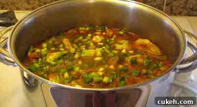 Adding a bit more water to help the artichokes cook moschari-me-agkinares