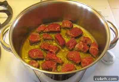 Add beef to hot oil for beef with artichokes moschari-me-agkinares