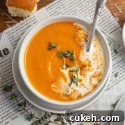 This is a square picture of a bowl of roasted tomato butternut squash soup.