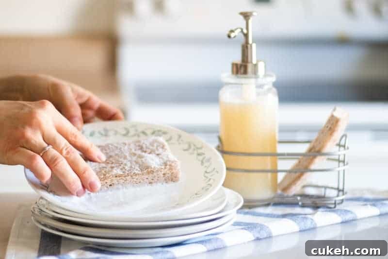 DIY Liquid Dish Soap Recipe: Affordable, Eco-Friendly Cleaner 2 washing white plate with homemade dish soap