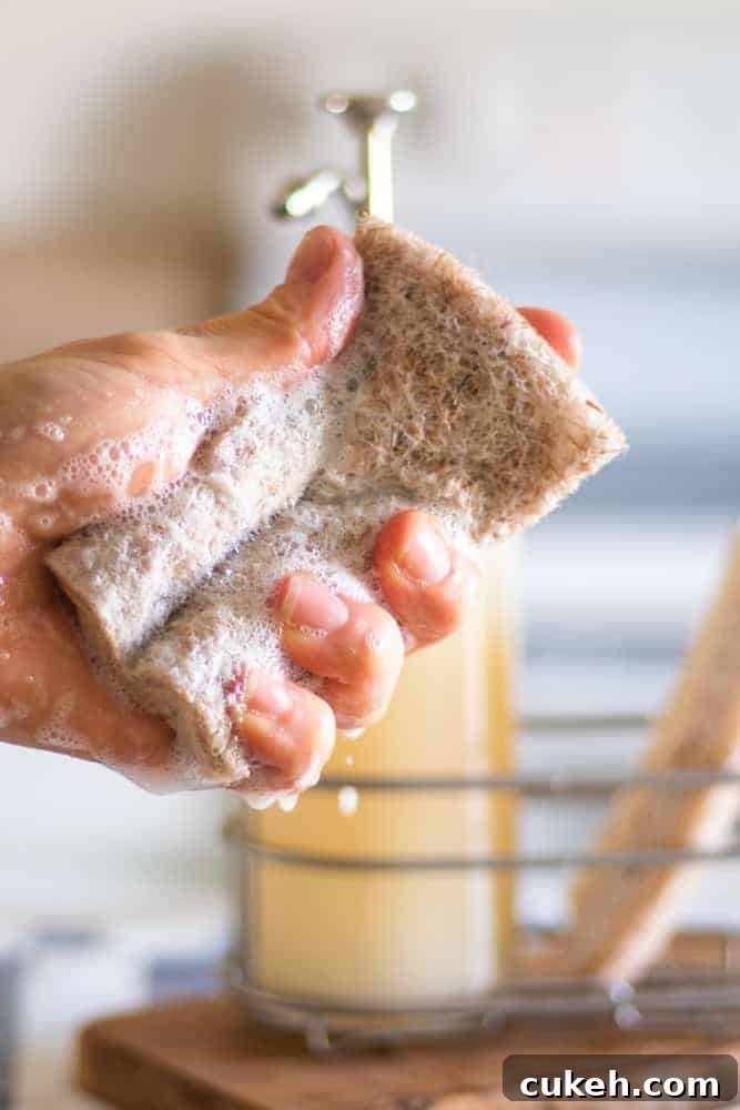DIY Liquid Dish Soap Recipe: Affordable, Eco-Friendly Cleaner 5 sudsing up dish soap in in a sponge