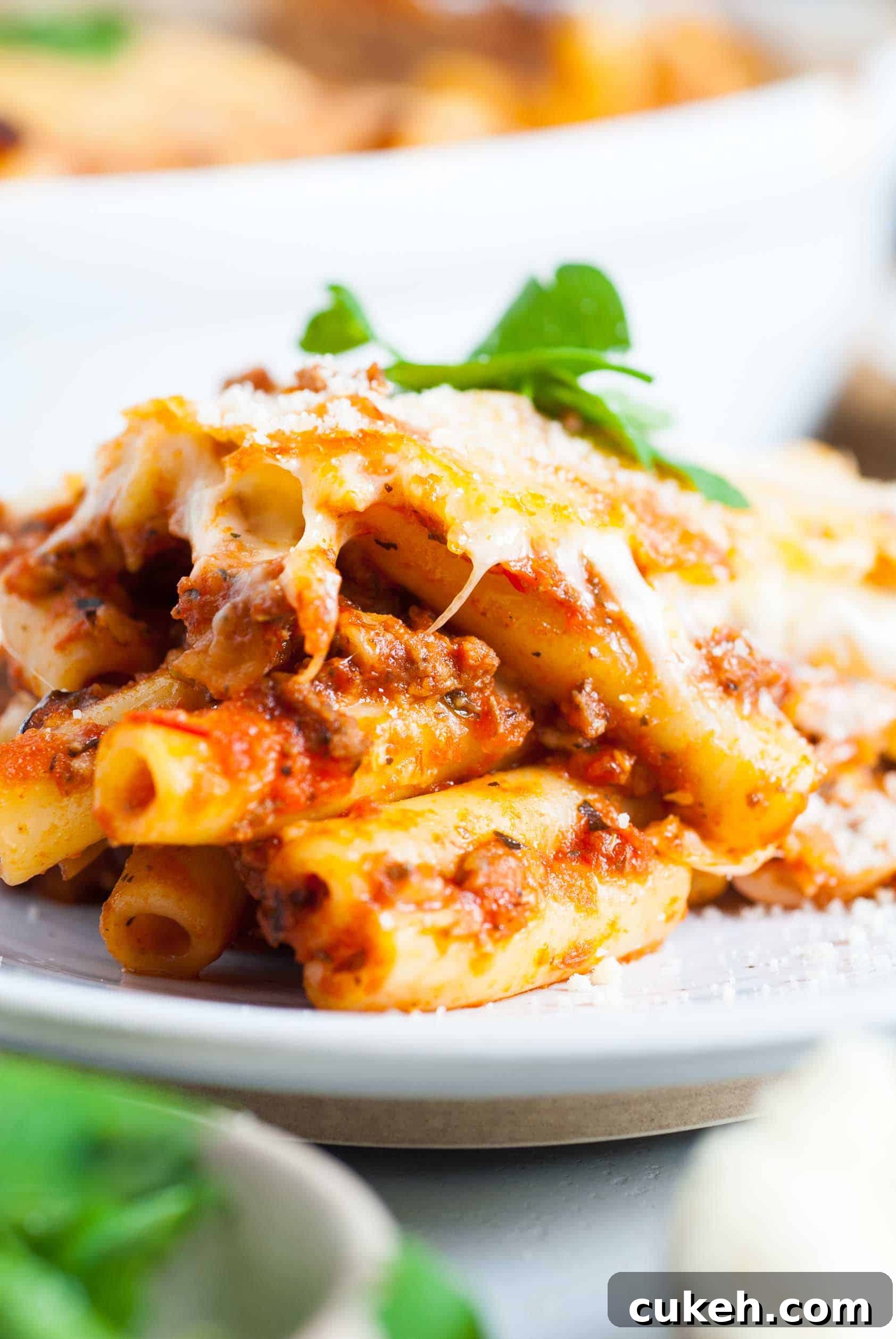 Cheesy baked ziti on a white plate.