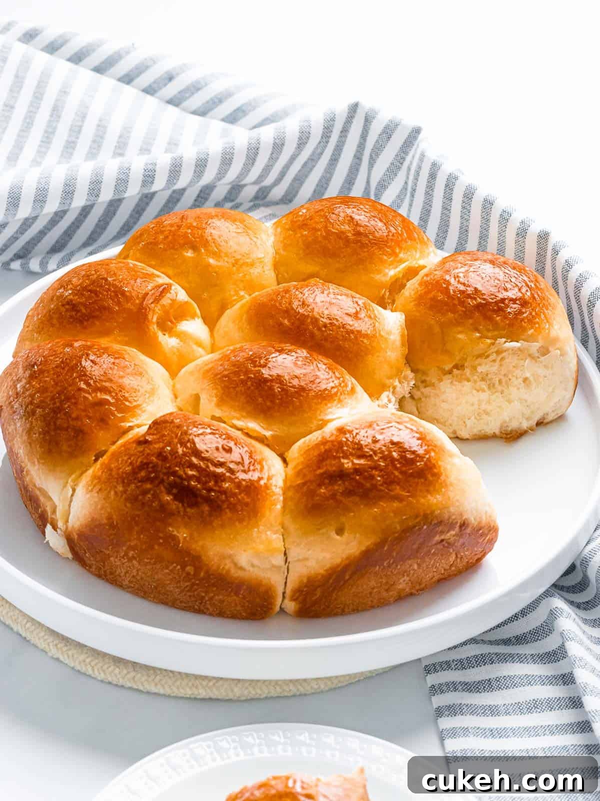 Soft and fluffy brioche rolls with a golden brown crust on a white plate.