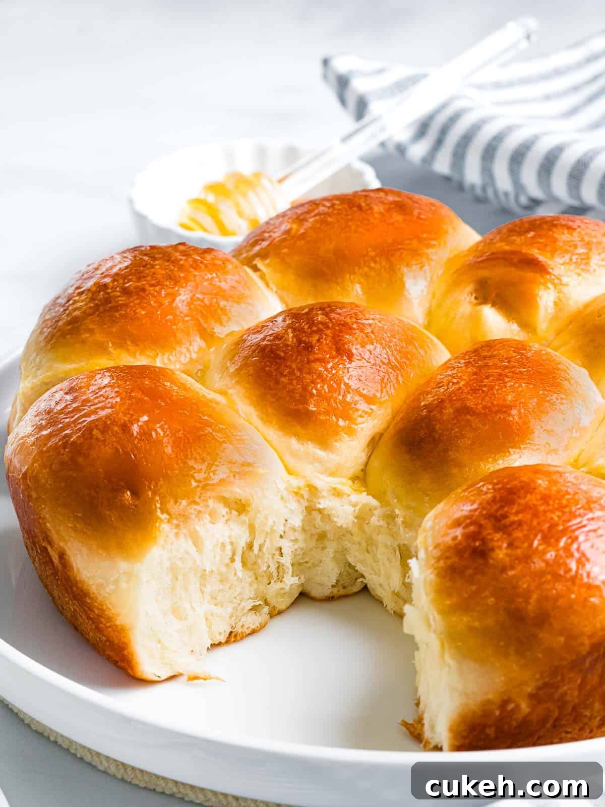 Soft and sweet brioche rolls with fluffy interior on a white plate.