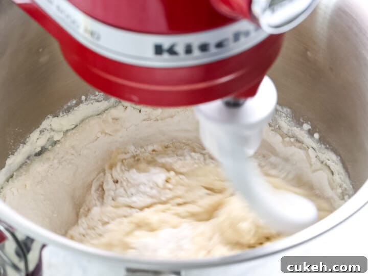 Brioche dough being mixed in a stand mixer.