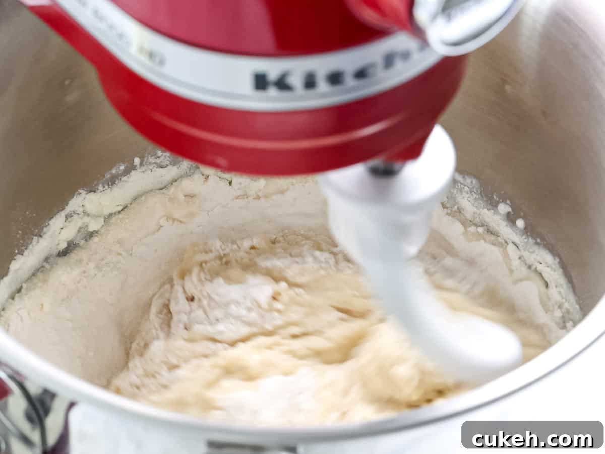Brioche dough being mixed in a stand mixer.