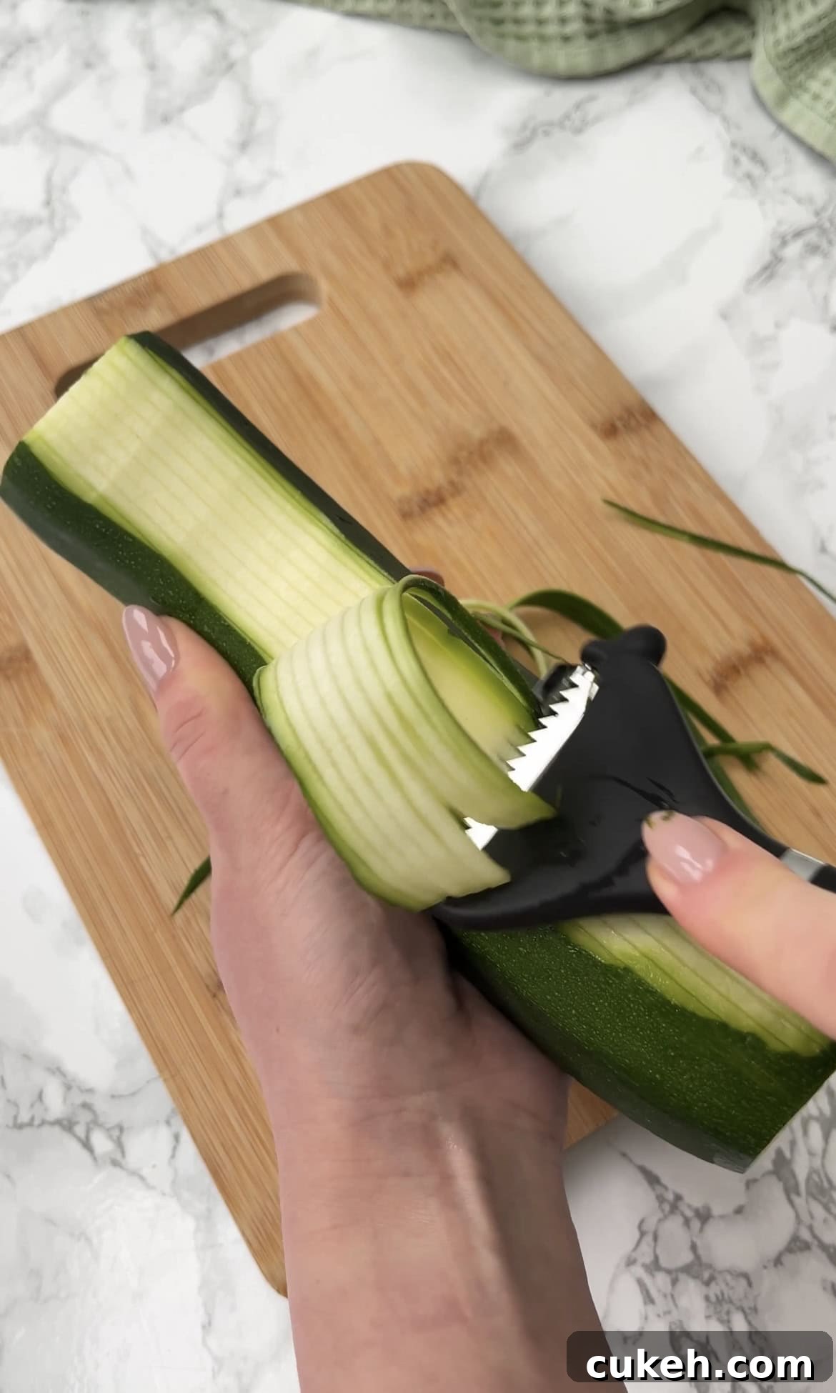 using a julienne peeler with a courgette.
