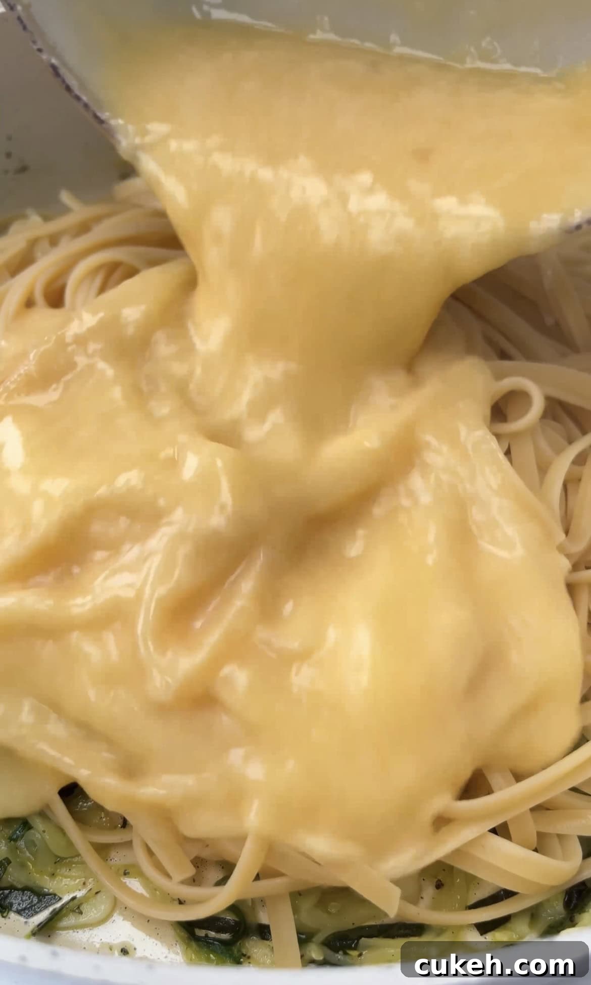 pouring eggs into pasta.